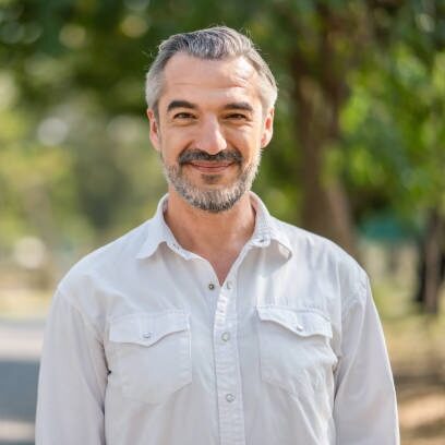 Portrait of senior man smiling and loooking at camera in the park.Retirement relax concept